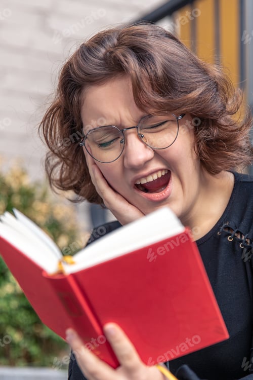 Preview: Tired and sleepy young woman reading a book. Emotion concept.