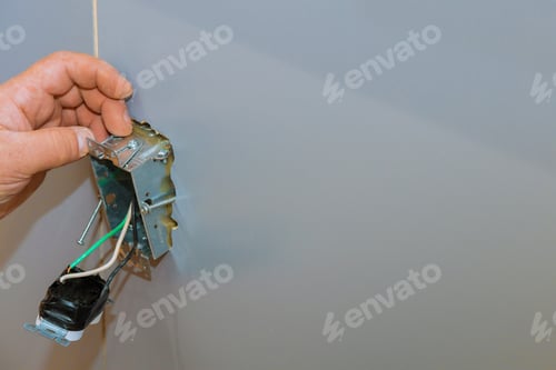 Preview: Installation of electrical sockets in closeup of hand of electrician installing wall