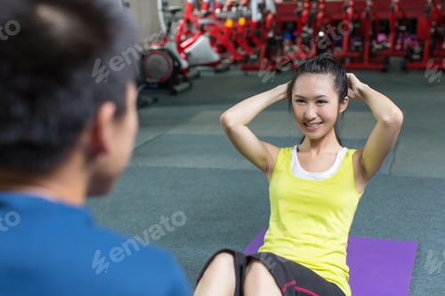 Preview: Professional fitness coach training fit woman in the gym