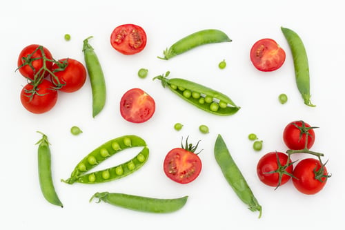 Preview: Red cherry tomatoes and green peas on white wooden table
