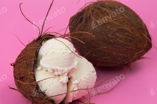Preview: Vanilla ice cream balls in an empty coconut decorated with mint leaves on a pink background