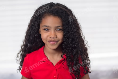Preview: Portrait of girl with curly black hair looking at camera smiling