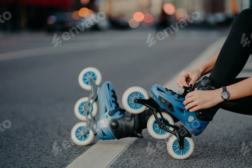 Preview: Legs of unrecognizable woman puts on rollerskates going to have exercises outdoor