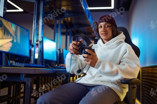 Preview: Young cheerful gamer holds headset in game club