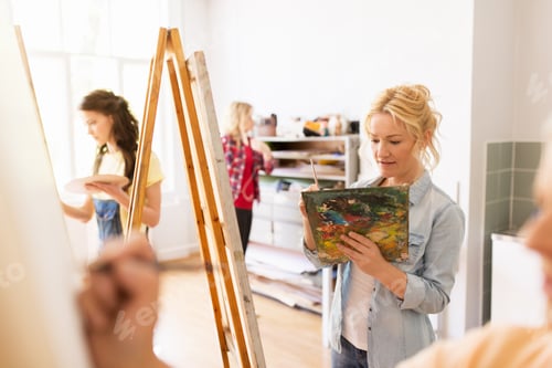 Preview: woman artist with easel painting at art school