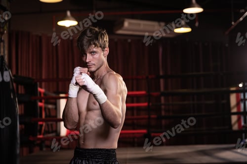 Vista previa: Hombre fuerte preparando la práctica de boxeo en el gimnasio.