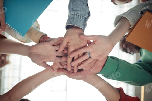 Preview: Below angle of pile of hands of group of teenage students in casualwear