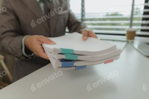 Preview: An office worker is putting important documents together to keep everything safe. A businessman is p