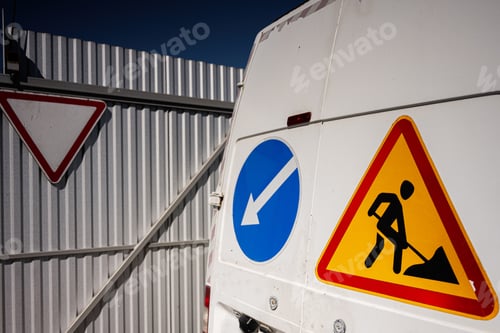 Preview: Construction vehicle with directional and warning signs on a sunny day