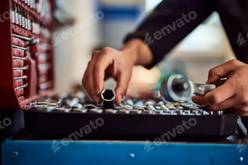 Preview: Side view of a mechanic man taking the lug bolt tool out of his tool case.