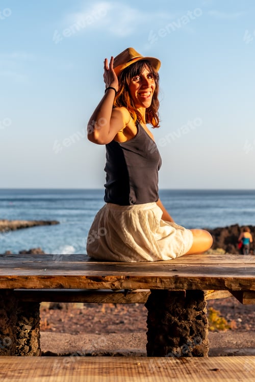 Preview: A woman tourist at sunset looking at the sea on the beach of Tacoron on El Hierro, Canary Islands