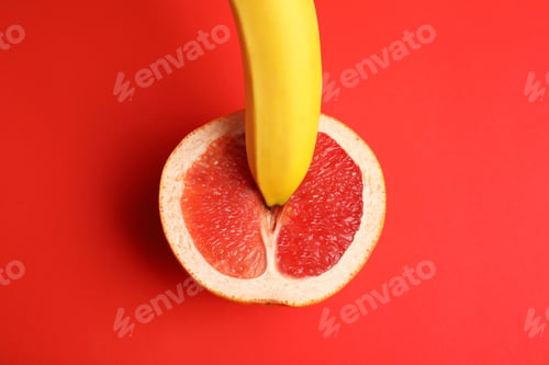 Preview: Fresh grapefruit and banana on red background, top view. Sex concept