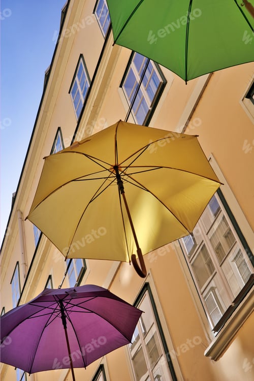 Preview: Low angle shot of colorful umbrellas in a narrow street in Sunnhof, Vienna, Austria