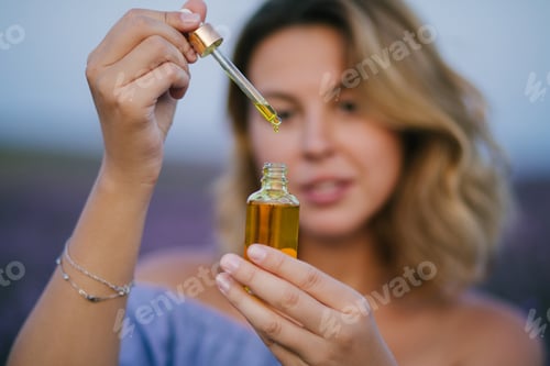 Preview: Woman holding bottle with essential oil, close up