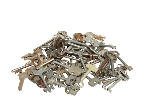 Preview: Pile of rusty silver keys on a white surface