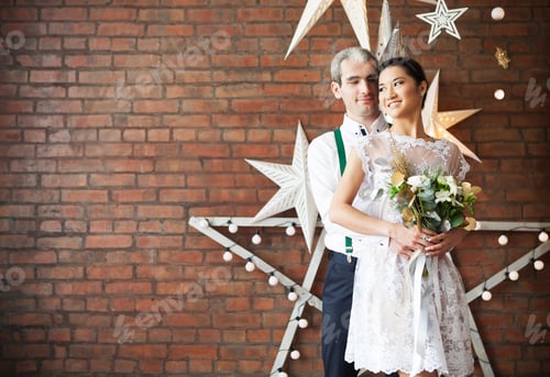 Preview: Cheerful couple near the brick wall decorated with the stars