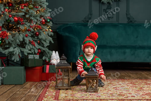 Preview: Little child under Christmas tree. baby boy in Santa Claus hat with gifts under Christmas tree with