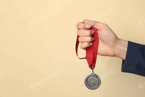 Preview: Woman holding golden medal on color background, closeup. Space for text