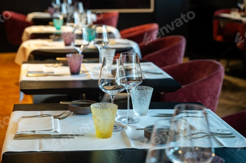Preview: Symmetrical tables prepared meticulously for service featuring elegant glassware