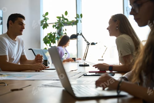 Preview: Woman looks at colleague in front of him while discussing task