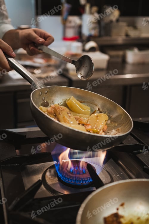 Preview: Close up of chef cooking rigatoni pasta on a metal pan at an italian restaurant