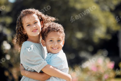 Preview: Portrait of a mixed race brother and sister smiling, standing and embracing each other in a garden