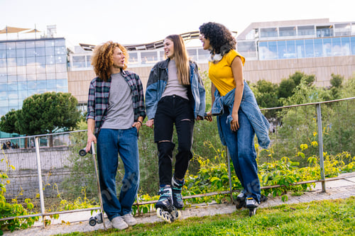Preview: Friends enjoying afternoon together skating and skateboarding in urban park