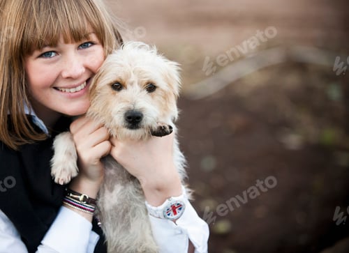 Preview: A woman hugging a small hairy terrier puppy.