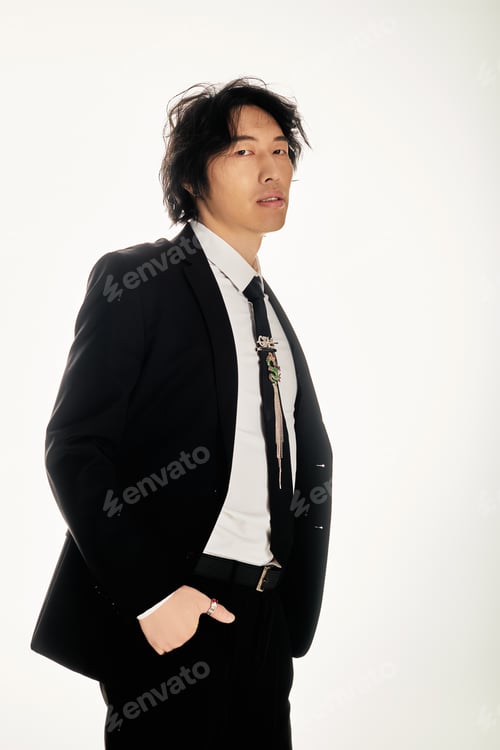 Preview: Stylish young asian man poses confidently in a modern urban setting wearing a chic suit