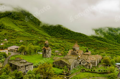 Preview: Drone view of Haghpat monastery on top of a green hill full of houses in Armenia