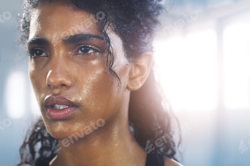 Preview: Close up shot of a focused and sweaty young sportswoman gathering her thoughts in the gym