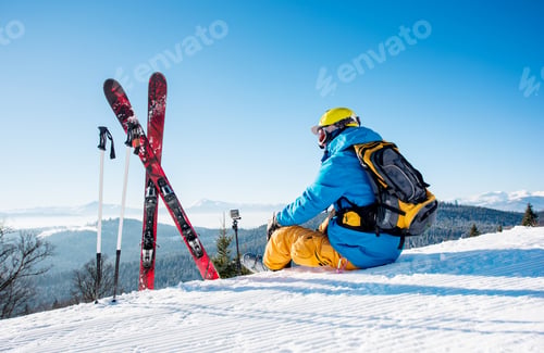 Preview: Skier resting on top of the mountain