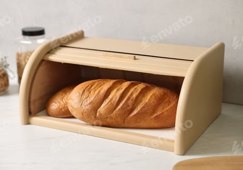 Preview: Wooden bread basket with freshly baked loaves on white marble table in kitchen