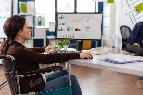 Preview: Paralyzed businesswoman in wheelchair typing marketing strategy working at company