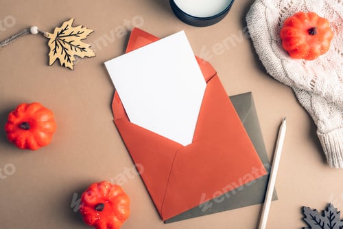 Preview: Autumn flat lay with orange envelope, blank card, pumpkins, leaf decoration and cozy sweater.
