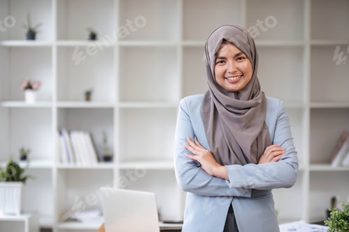 Preview: A portrait of a beautiful and professional Asian Muslim businesswoman stands in the office with her