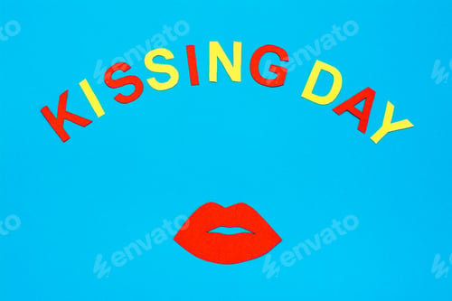 Preview: World Kiss Day. Red lips and the inscription kissing day made of cardboard on a blue background.