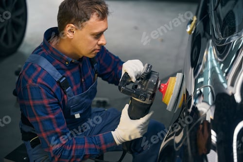Preview: Employer working with automobile part, polish surface