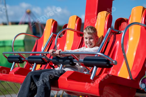 Preview: Teen boy riding amusement park attraction, fun and summer entertainment concept