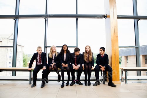 Preview: Portrait of teenage schoolchildren sitting in corridor