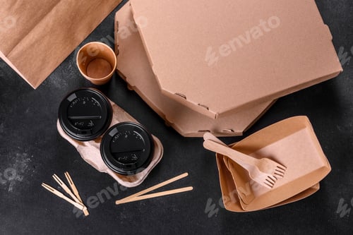 Vista previa: Disposable dishes made of environmentally friendly brown cardboard on a dark background