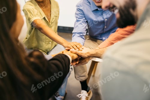 Preview: Business colleagues stacking hands in group teamwork