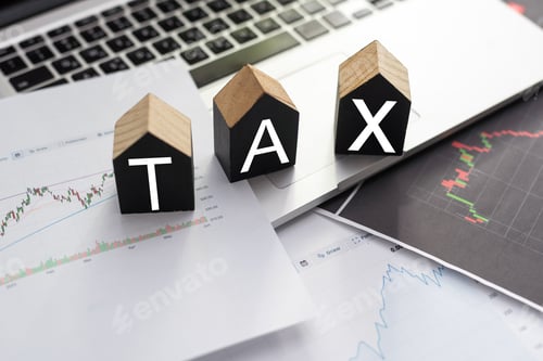 Preview: the word TAX is laid out of wooden cubes with letters on white background with coins
