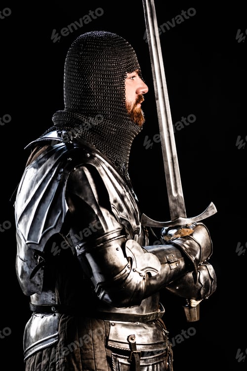 Preview: side view of handsome knight in armor holding sword isolated on black