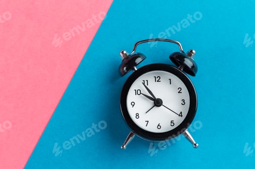 Preview: Vintage black alarm clock on a color block background