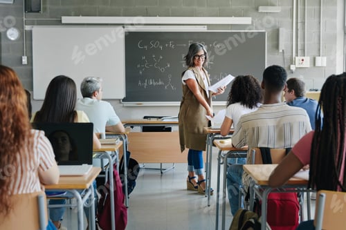 Preview: Female teacher giving exam sheet to High School students learning technology and science