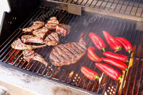 Vista previa: Jugosos filetes y pimientos morrones chisporroteando en una parrilla