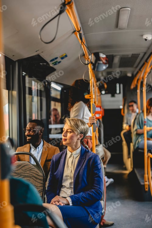 Preview: Businesswoman sitting on bus looking out window during commute