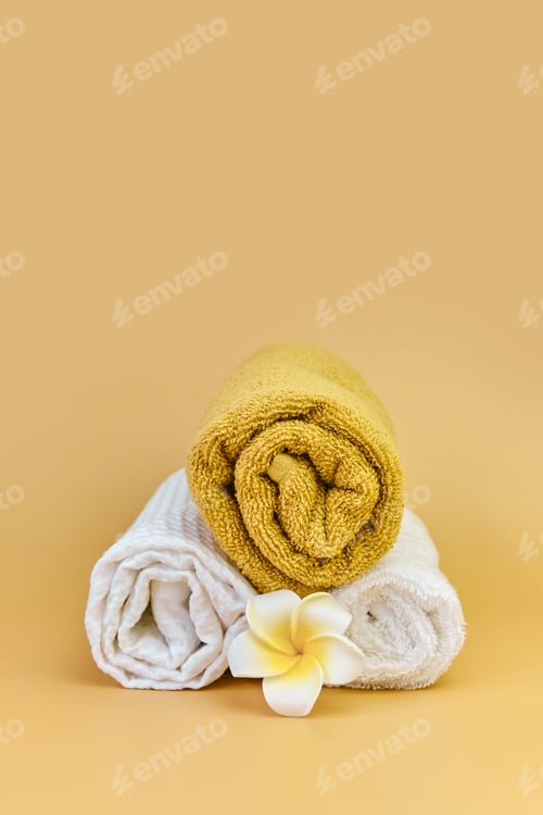 Preview: Stack of roll folded towels on a beige background,