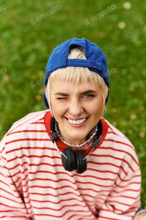 Preview: Stylish young woman enjoys a sunny day in a vibrant park setting with a playful smile